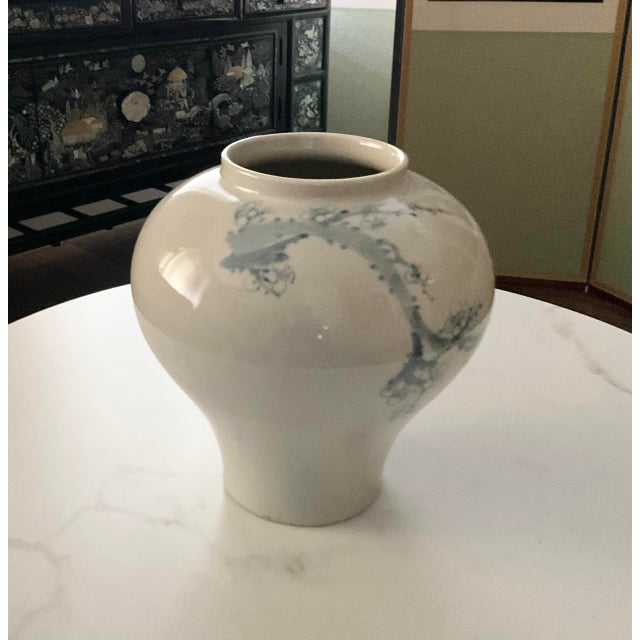 This is white celadon style pottery with cherry flower design. It is very full at the top and tapered narrowly at the...