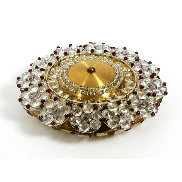 Stylish mid-century modern ceiling lamp made of different sized transparent and purple glass stones on a round brass...