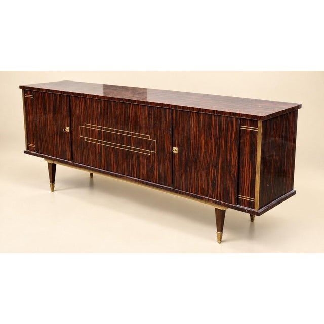 Art Deco style sideboard, circa 1960s, entirely veneered in Macassar ebony with a flamed, reddish-brown-orange grain on a...