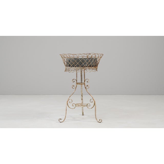 20th century French white painted metal flower stand showcasing graceful scrollwork and charming patina from natural age....