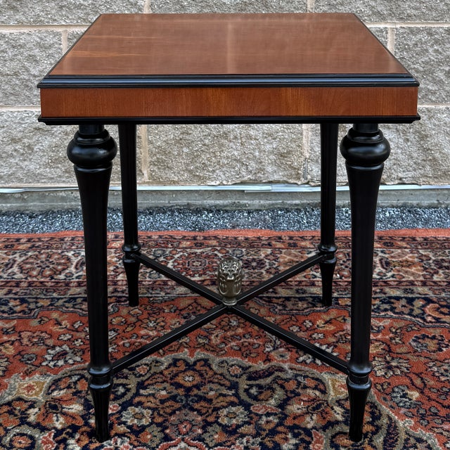 A vintage Bombay Furniture Traditional Regency side table having an auburn cherry top with ebonized base featuring turned...