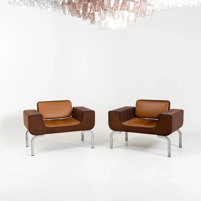 Pair of lounge chairs with brown leather upholstery in original condition.