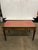 writing desk with a rectangular top inset with a red-orange tooled leather writing surface, brass gallery edge, three...