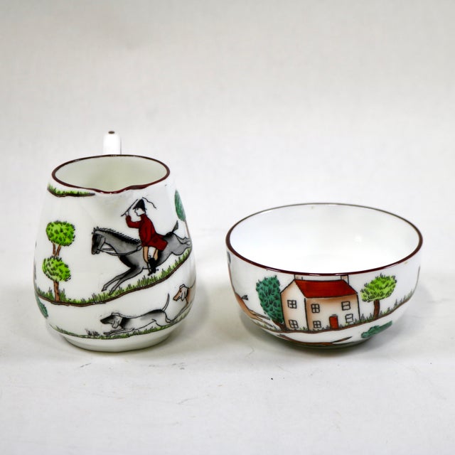 A vintage fine bone china mini creamer and open sugar bowl in Crown Staffordshire’s classic “Hunting Scene” pattern,...