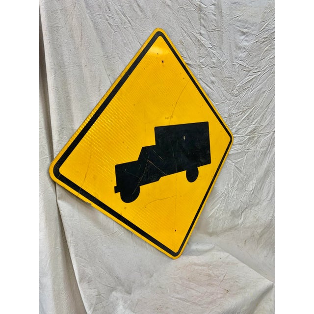 This Vintage Reflective Road Sign depicts a black truck with a yellow background. Once used as a street sign to inform...