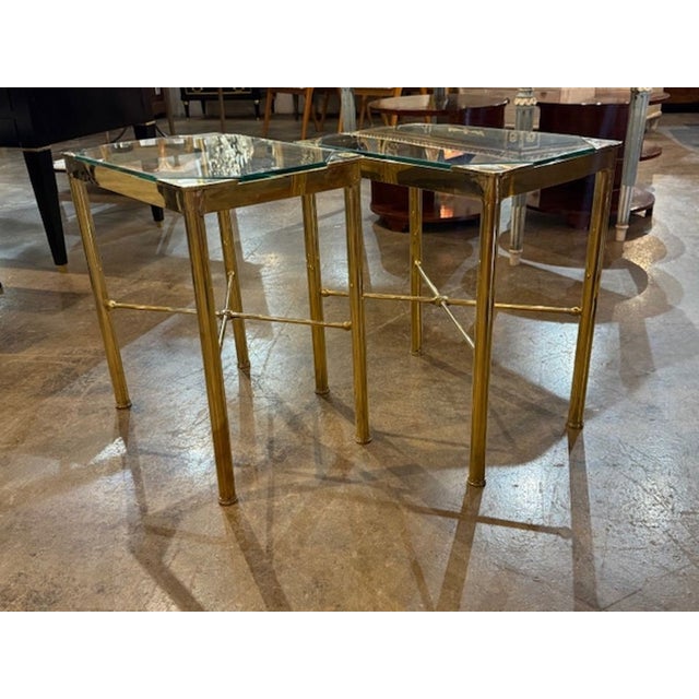 This product is a pair of elegant Italian Hollywood Regency style brass and glass side tables. These create a stylish...