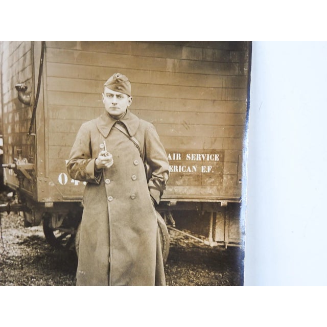 Circa 1918 silver gelatin photograph of US soldier or pilot. Standing in front of a transport for Air Service American...