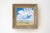 This oil painting captures a serene landscape under a vast sky filled with soft, billowing clouds. The gentle brushwork...
