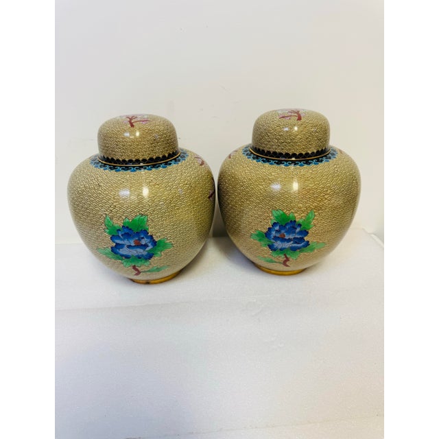 pair of vintage cloisonné ginger jars featuring a blossom and bird motif. Material and Technique: These jars are crafted...
