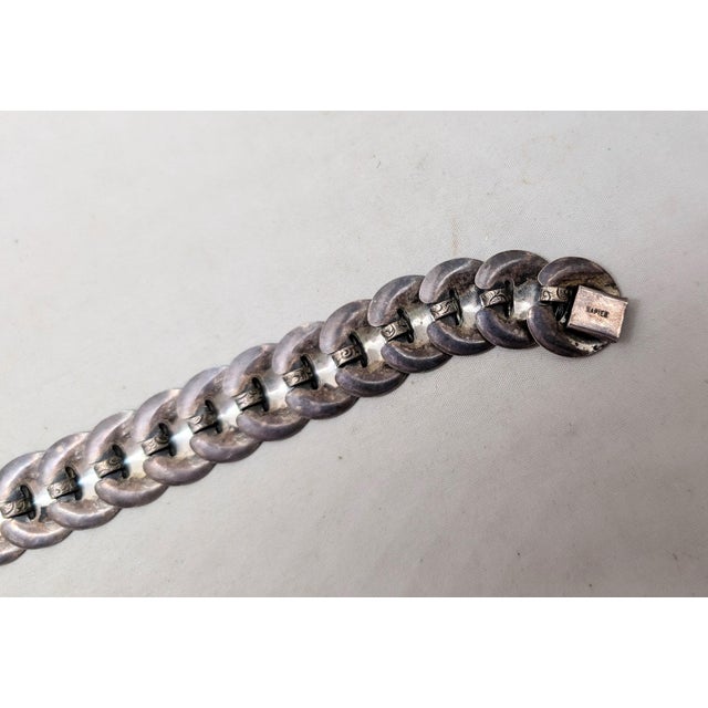 Early 1950s silvertone circular links with etched cloud and star design bracelet with box clasp. Marked "NAPIER."...