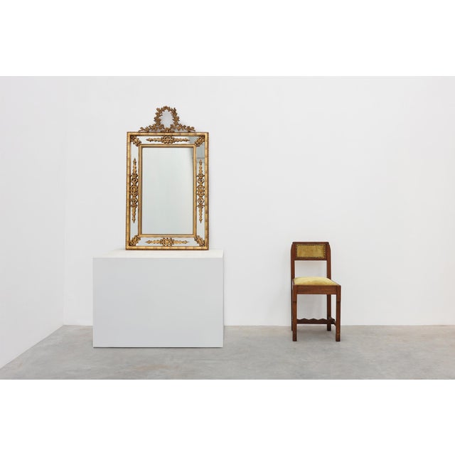 An elegant Louis XVI style wall mirror crafted in Belgium during the 20th century, richly decorated with neoclassical...
