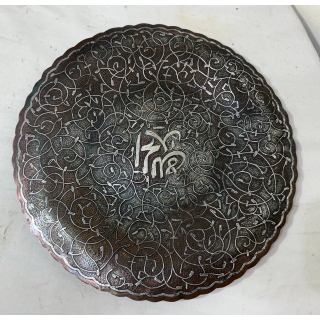 This thick antique handmade Middle Eastern sterling silver inlay over copper decorative plate is a unique and ornate piece...