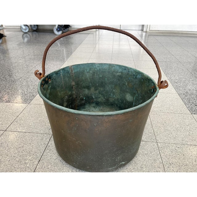 This antique copper cauldron was hand-crafted in France in the 19th Century. It has a hand-forged iron handle and rounded...