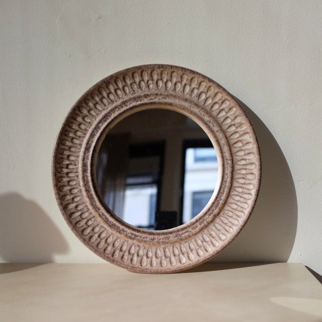 Charming Danish Mid-century Ceramic Wall Mirror in a beige/brown glaze with an etched ceramic border around the round...