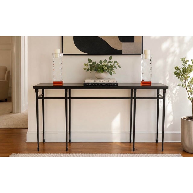 An exceptional Holly Hunt Studio “Rue De Seine” console table featuring a substantial black marble top resting atop a...