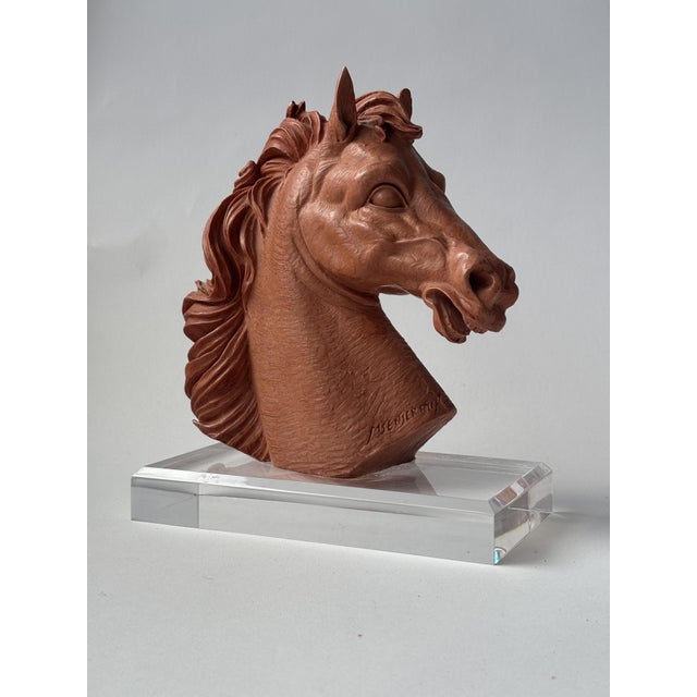 Small horse head sculpture on acrylic base This delicate sculpture depicts a finely detailed horse head, crafted from warm...