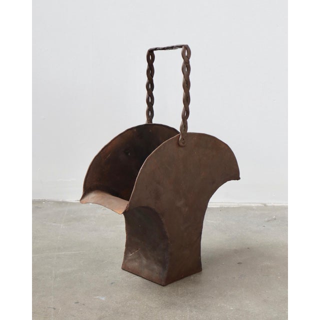Brutalist iron basket with a sculptural twisted handle, dated by the owner to approximately the 1960s–1970s. It has...
