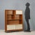 Vintage wooden bookcase with shelves and open compartments, sliding and flap doors. This piece is attributed to the...