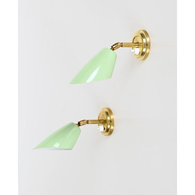 Marvelous and rare pair of sconces in brass and pistachio green enameled metal. Completely original and in amazing...
