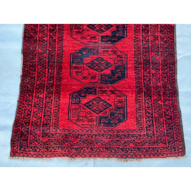A moody, character-rich vintage Afghan Khal Mohammad Bokhara rug — five large dark-ground octagonal "Aina" (mirror) guls...