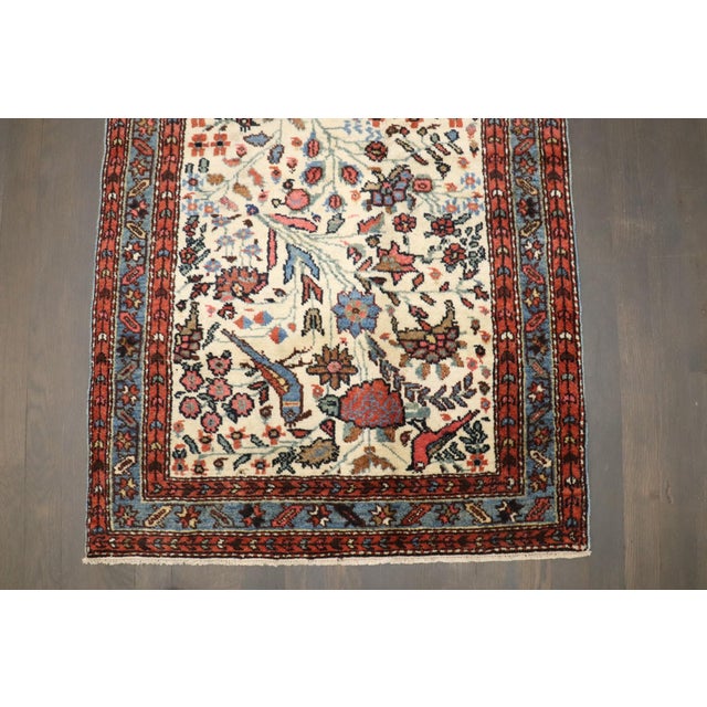 A persian rug from the 1930s depicting a pictorial bird design on an ivory ground