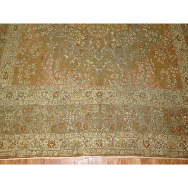 A fine Persian Tabriz rug predominantly orange including some silver, olive and ivory shades as well. The medallion...