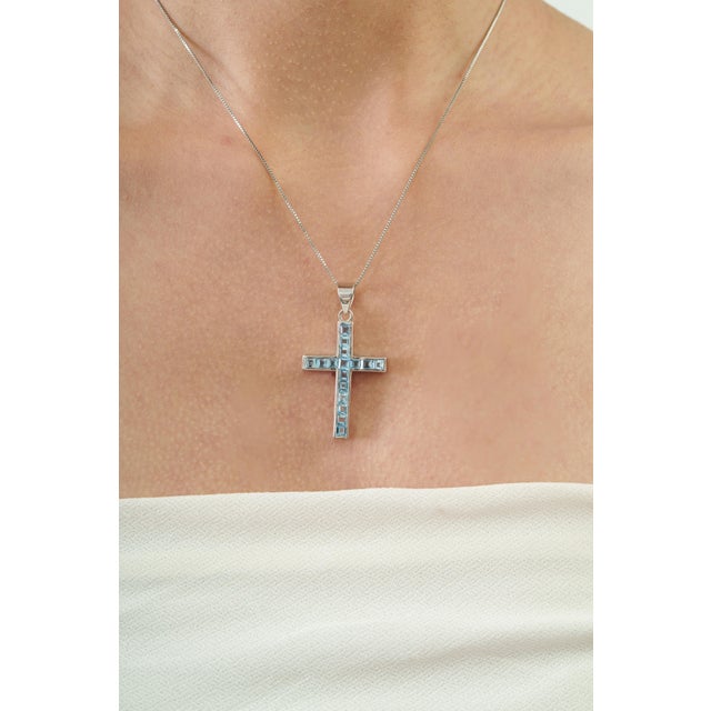 The Handcrafted Modern Style Natural 3.09 Ct Sky Blue Topaz & Sterling Silver Cross Pendant features a clean, geometric...