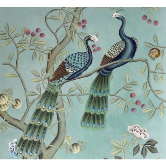 Elegant hand-painted chinoiserie mural set with muted soft mint backdrop, intricately detailed with paired peacocks...