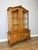 An elegant Vintage French Louis oak bookcase featuring a glazed upper display section, decorative shaped detailing and a...