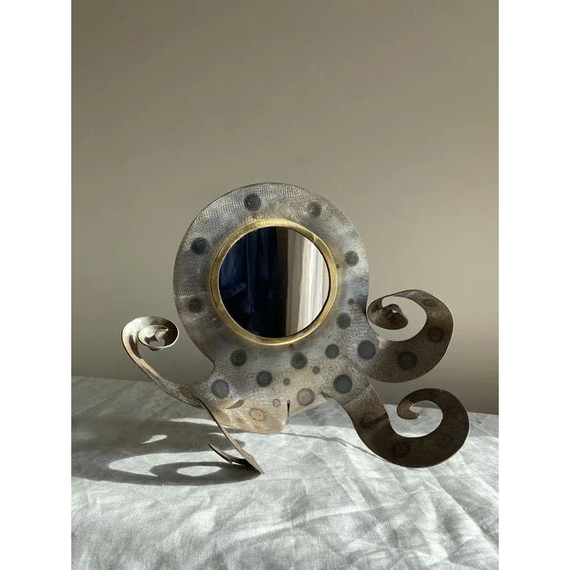Amazing vintage mirror in the form of a squid / octopus. Bent and hammered steel with a brass trim holding a circular...