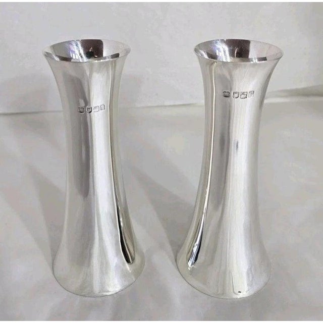 A fine pair of Edwardian sterling silver flower or spill vases dating to the early 20th century, displaying an elegant and...