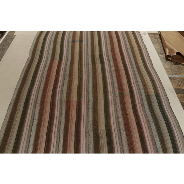 Handwoven in wool, a vintage Turkish kilim rug, connoting a rare variant of mid-century panel weaving styles circa...