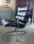 This is a vintage office chair featuring brown leather upholstery divided into multiple padded cushions, set within an...