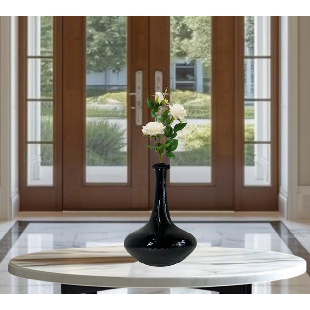 A stunning Murano art glass vase featuring an elegant mid-century modern silhouette and dramatic optic ribbed decoration....