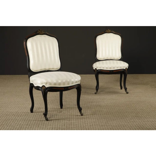 This intriguing pair of 1890s French Louis XV style chairs in the style of Rinquet-Leprince feature elaborate carving of...