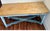 A charming antique Belgian farmhouse table featuring a beautifully weathered painted base in soft blue-gray tones and a...