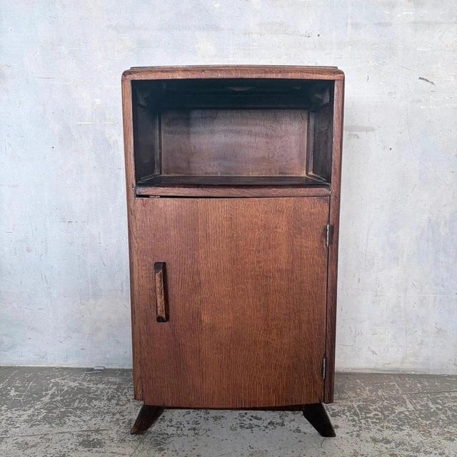 a compact 1950s oak bedside cabinet with useful drawer and cupboard storage. Its neat footprint and warm oak grain make it...
