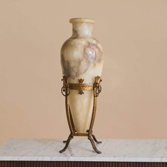 A 20th century French alabaster vase with gilt metal stand, rising just over 30 inches tall. Carved from softly veined...