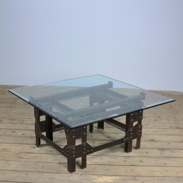Coffee / salon table with a base of heavy riveted cast iron with an Italian crystal glass top. The cast iron base was made...
