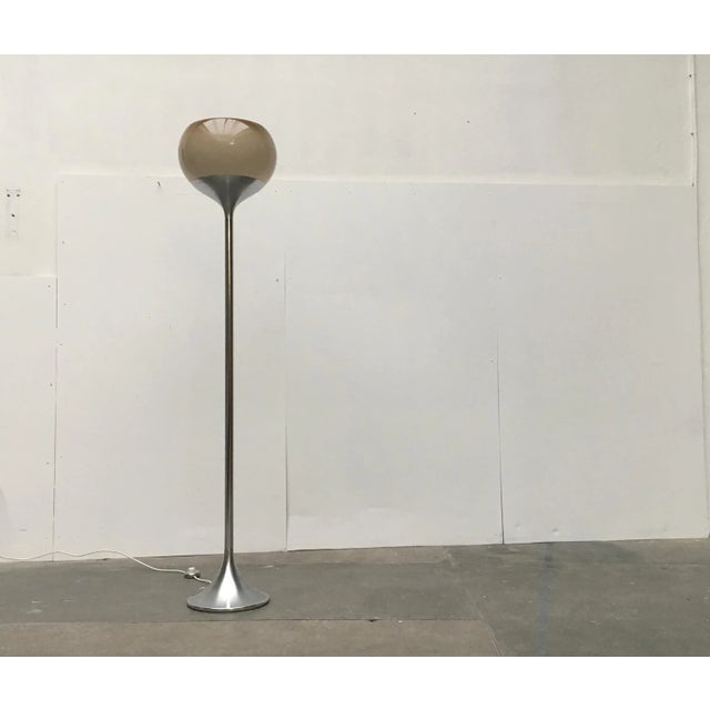 Rare Mid Century floor lamp from Guzzini. The classic Guzzini plastic shade is turned in this design so that the lamp acts...