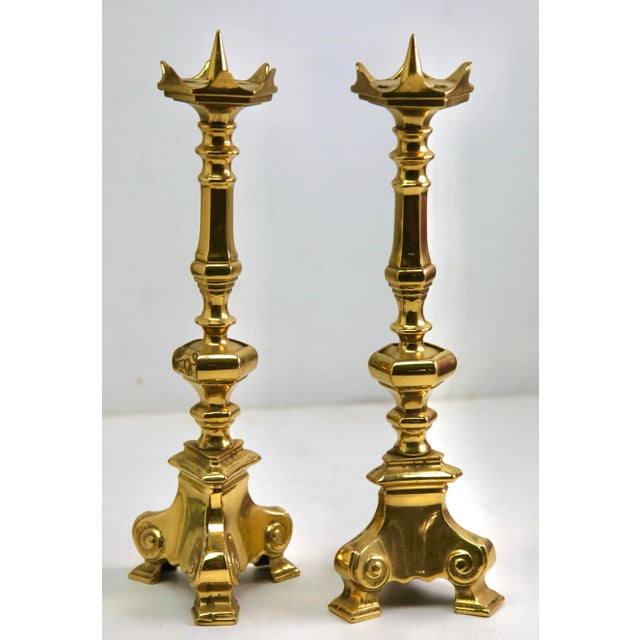 Antique pair of solid brass candlesticks. The solid brass is sharply cast and well defined, and are an identical pair....