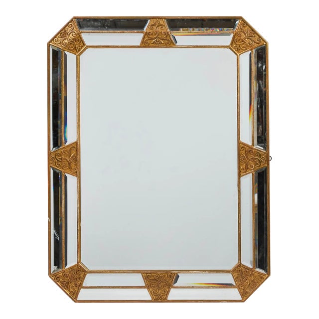 Deco period, stepped and beveled mirror with hand-carved giltwood accents around inset mirror panels.