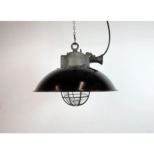 Industrial hanging lamp manufactured by Elektrosvit in former Czechoslovakia during the 1960s. It features a black enamel...