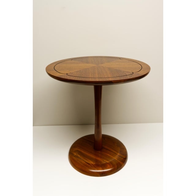A Mid Twentieth Century Modern side table crafted from rich walnut, featuring a beautifully matched veneer top and a clean...