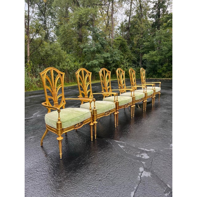 An eye catching set of six vintage dining armchairs in gilded cast aluminum with a sheaf of wheat motif, fluted and...