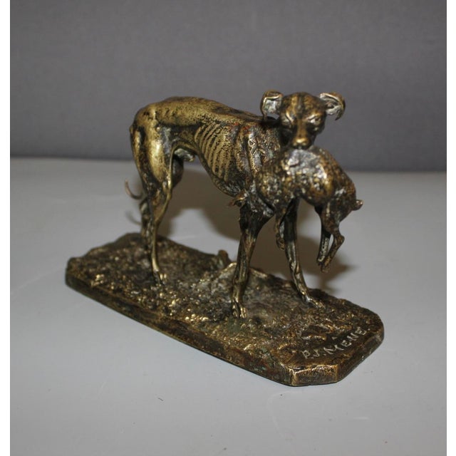 Bronze animal sculpture, "greyhound with hare," depicting a greyhound holding a hare in its mouth, signed in relief on the...