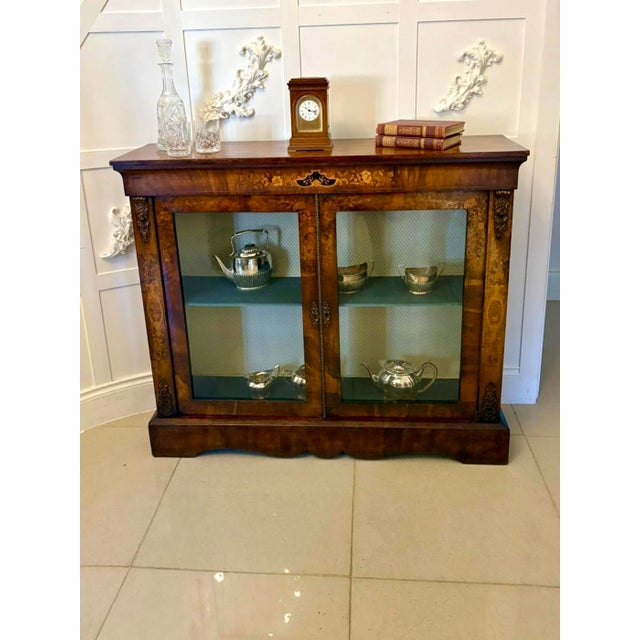A fine quality Victorian figured burr walnut display cabinet richly adorned with exquisite floral marquetry inlay. The...