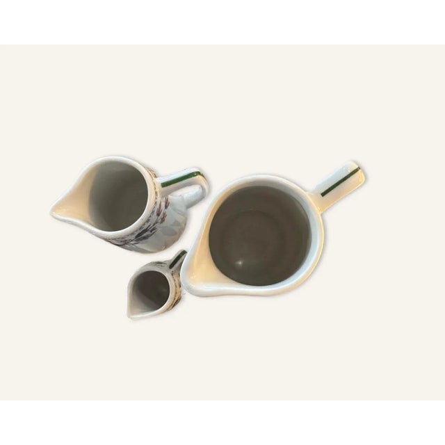 3 white porcelain pitchers of varying sizes, all from the Greenbrier Hotel in White Sulphur Springs, West Virginia. These...