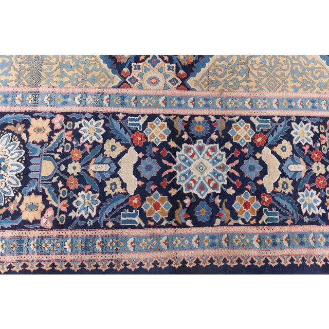 This antique Indian rug reflects the rich heritage of traditional Indian weaving, likely inspired by Mughal-era...