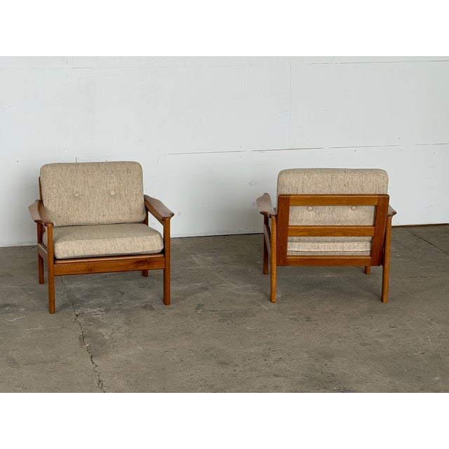 A pair of Danish teak lounge chairs, 1960s. Solid teak frames with a clean, open construction that reads well from every...